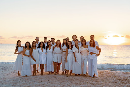 L'équipe d'IMMO Investments au bord de la mer posant pour une photo de groupe.